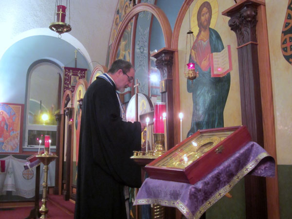 Father Paul reads prayers in front of the Icon of the Virgin.